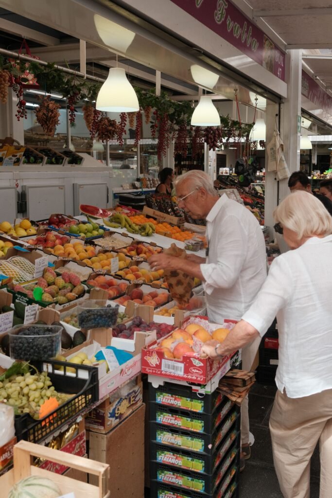 Senior couple selecting fresh fruits at a vibrant outdoor market.